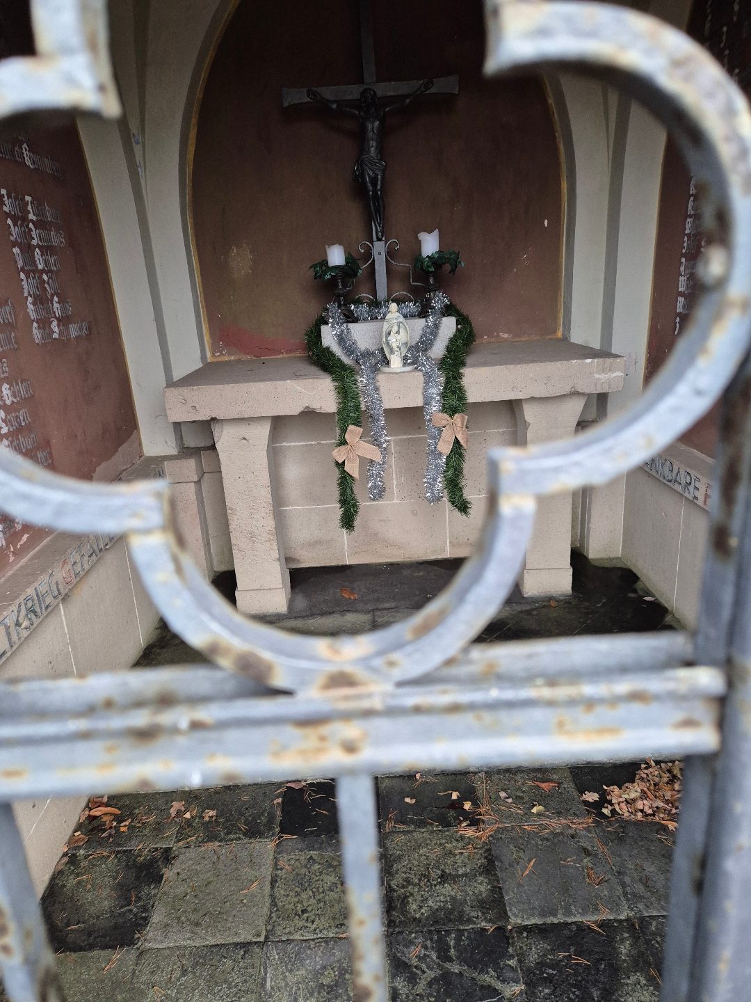 Blick durch das ornamentale Eisengitter auf den weihnachtlich geschmückten Altar, Dezember 2025