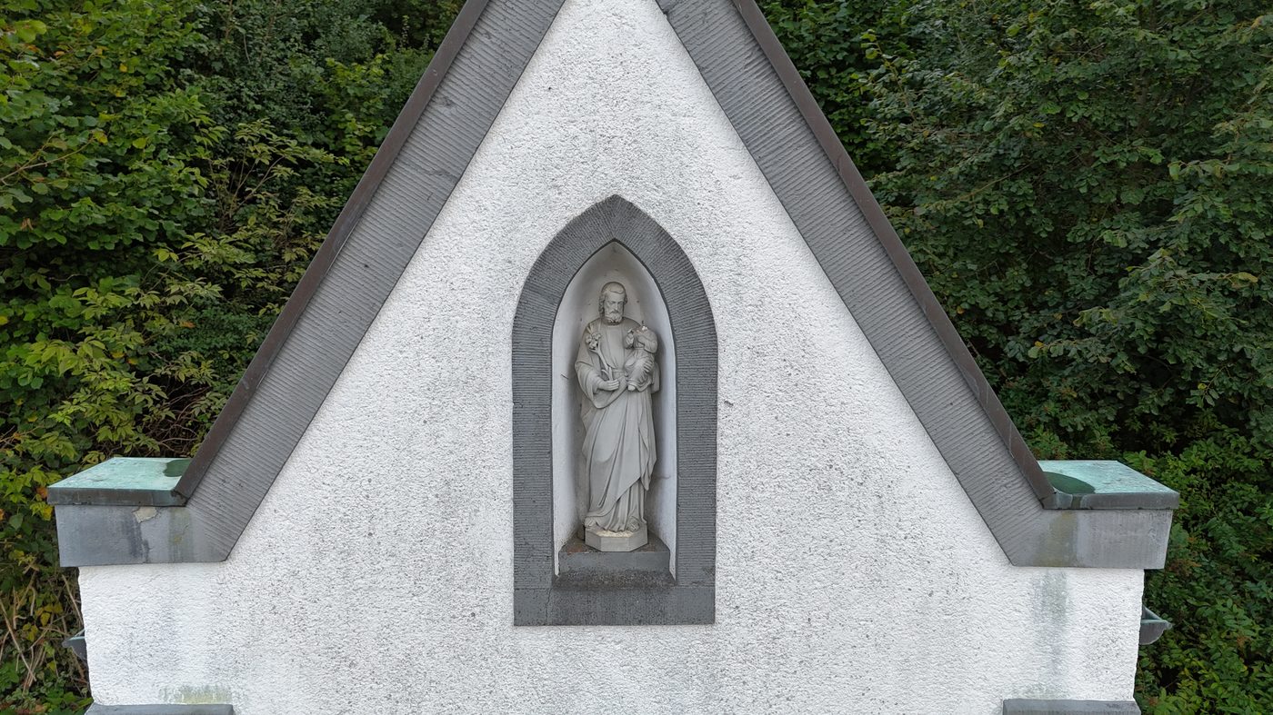 Drohnen-Nahaufnahme: Giebel mit Heiligenstatue aus der Vogelperspektive